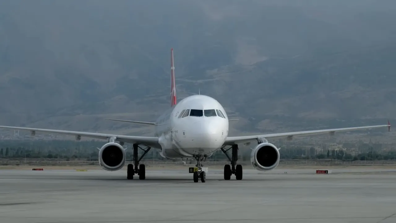 Commercial passenger jet viewed head-on on the tarmac at an airport, ready for taxi or takeoff.